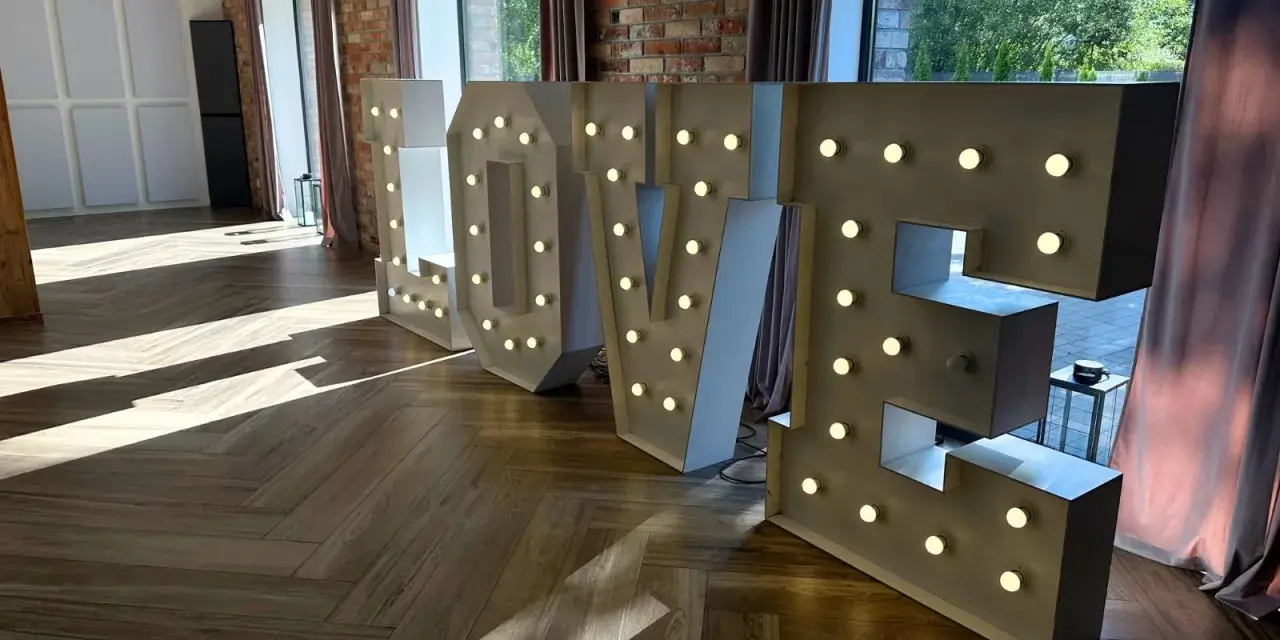 Podświetlane litery LOVE, idealne atrakcje na wesele, tworzą romantyczną atmosferę.