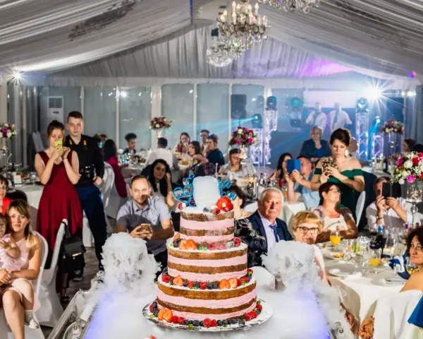 Efektowny tort weselny z owocami i dymem, goście robią zdjęcia. Cena takiego cudu może być zaskoczeniem!