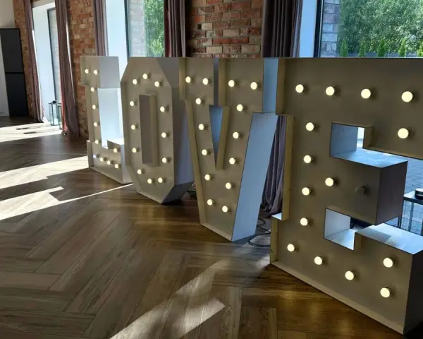 Podświetlane litery LOVE, idealne atrakcje na wesele, tworzą romantyczną atmosferę.