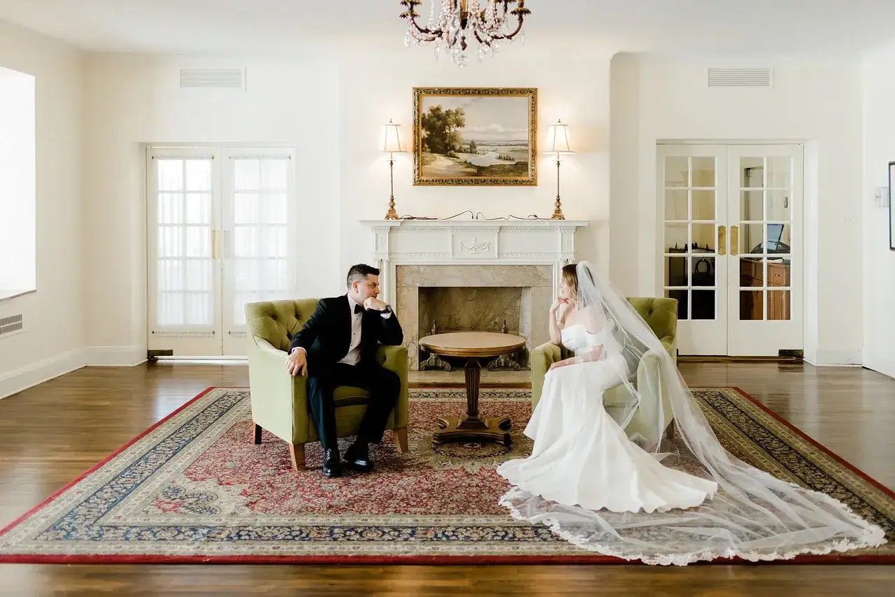 Para młoda siedzi naprzeciwko siebie w eleganckich fotelach. Zastanawiają się, ile trwa ślub cywilny, zanim rozpoczną swoją wspólną podróż.