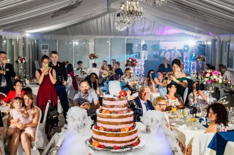 Efektowny tort weselny z owocami i dymem, goście robią zdjęcia. Cena takiego cudu może być zaskoczeniem!